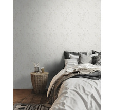 Schlafzimmer mit floral gemusterter Tapete, Bett und Korbtisch