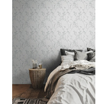 Schlafzimmer mit Wandtapete mit Pflanzenmuster und Doppelbett.