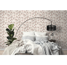 Schlafzimmer mit Bett vor einer Wand mit Blumentapete
