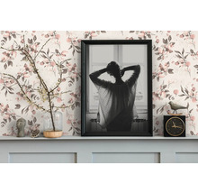 Dekoratives Arrangement mit Bilderrahmen, Uhr und Blumenvase vor einer floralen Tapete