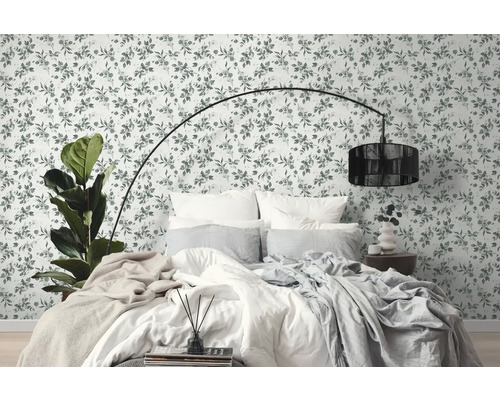 Schlafzimmer mit Blumentapete, Bett und Stehlampe