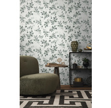 Dekoratives Zimmer mit Blättermuster-Tapete, Sessel, Regal und Teppich