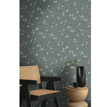 Szene mit einem Stuhl, einem Tisch und einer Wandtapete mit Eukalyptusmuster