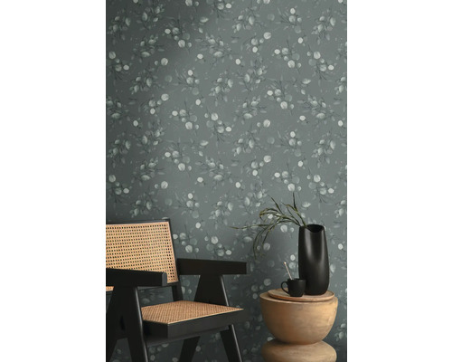 Szene mit einem Stuhl, einem Tisch und einer Wandtapete mit Eukalyptusmuster