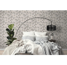 Schlafzimmer mit gemusterter Tapete, Bett und Stehlampe