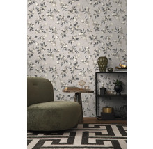 Raumansicht mit floral gemusterter Tapete, Sessel und Beistelltisch