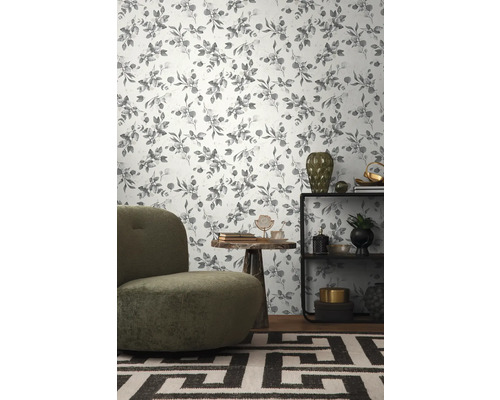 Dekoriertes Wohnzimmer mit einer Tapete mit Eukalyptuspflanzenmuster, einem Sessel, einem Tisch und einem Regal.