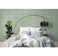 Schlafzimmer mit Bett vor grüner Wandtapete mit floralem Muster