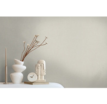 Dekoratives Arrangement mit Kerze, Vase mit Pflanzen, Uhr und Skulptur auf einem Tisch.