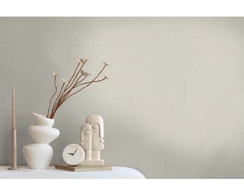 Dekoratives Arrangement mit Kerze, Vase mit Pflanzen, Uhr und Skulptur auf einem Tisch.