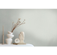 Dekorative Stilllebenanordnung mit Vase, Blumenzweigen, Kerze, Uhr und Skulptur