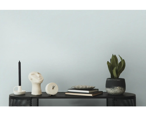 Dekoratives Arrangement mit Kerze, Skulptur, Uhr, Büchern, Schale und Pflanze auf einem Tisch