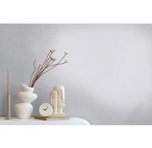 Dekorative Szene mit Vase, Trockenblumen, Kerze, Uhr und Skulptur auf einem Tisch.