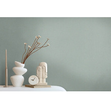 Dekorative Szene mit einer Vase, Zierblumen, einer Skulptur, einer Uhr und einer Kerze auf einem Tisch