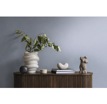 Dekorative Gegenstände und Pflanzen auf einem Holz-Sideboard