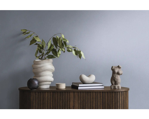 Dekorative Gegenstände und Pflanzen auf einem Holz-Sideboard