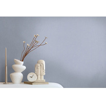 Dekorative Szene mit abstrakter Skulptur, Tischuhr, Vase und Kerze auf einem Tisch