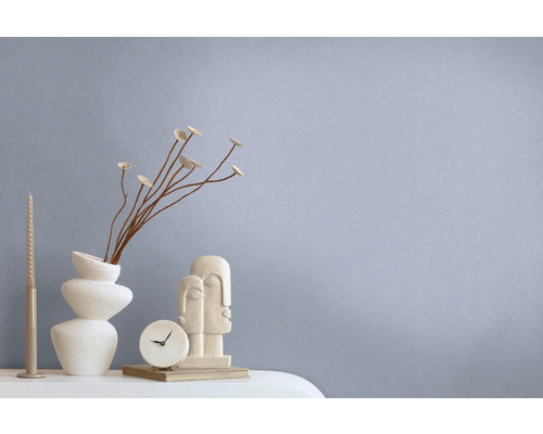 Dekorative Szene mit abstrakter Skulptur, Tischuhr, Vase und Kerze auf einem Tisch