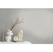 Dekorative Szene mit Vase, Skulptur, Uhr und Kerze auf einem Tisch.