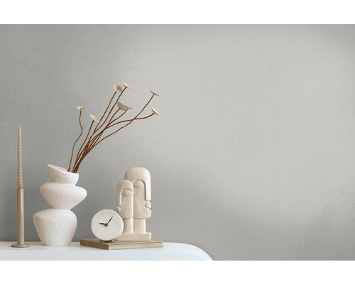 Dekorative Szene mit Vase, Skulptur, Uhr und Kerze auf einem Tisch.