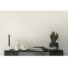 Dekorative Szene mit Kerze, Skulptur, Uhr, Büchern und Topfpflanze auf einer Konsole