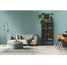 Wohnzimmer mit Sofa, Sessel, Stehlampe, Schrank und Esstisch