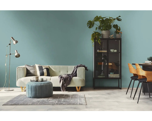 Wohnzimmer mit Sofa, Sessel, Stehlampe, Schrank und Esstisch