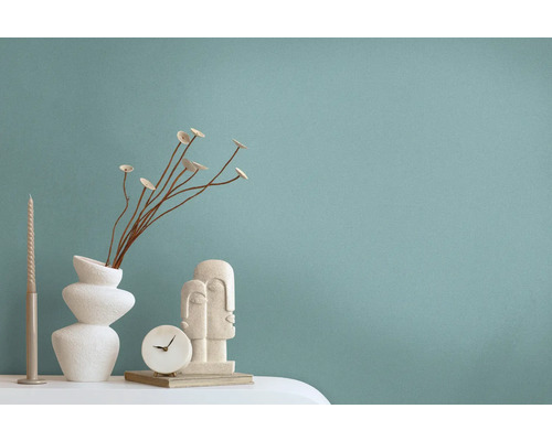 Dekorative Szene mit Vase, Trockenblumen, Kerze, Uhr und Skulptur auf einem Tisch.