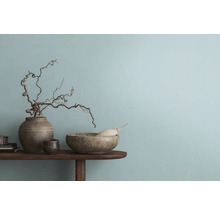 Dekoratives Arrangement mit Vase, Schale und Ästen auf einem Holztisch