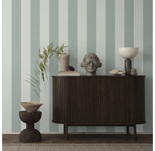 Einrichtungsgegenstände auf einem Sideboard vor einer Wand mit Streifenmuster.