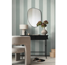 Modernes Interieur mit Konsole, Spiegel und Stuhl vor gestreifter Wand