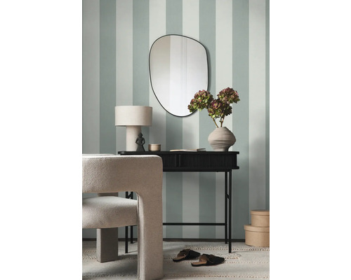 Modernes Interieur mit Konsole, Spiegel und Stuhl vor gestreifter Wand