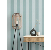 Zimmeransicht mit Stehlampe, Tisch und Dekoration vor gestreifter Tapete