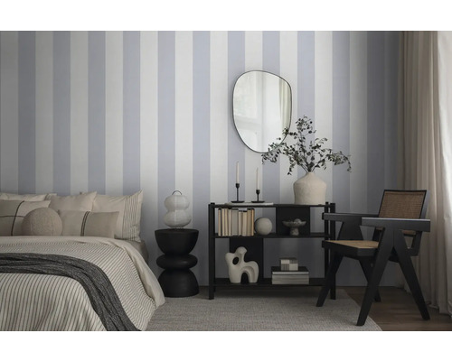 Schlafzimmer mit Bett, Kommode, Spiegel und gestreifter Tapete