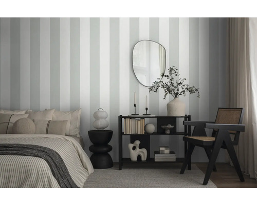 Schlafzimmer mit gestreifter Tapete, Bett, Spiegel und Regal