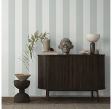 Interieur mit einem dunklen Holzschrank, Dekorationselementen und gestreifter Tapete.