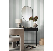 Dekoratives Interieur mit Spiegel, Tisch und Stuhl vor gestreifter Wandtapete