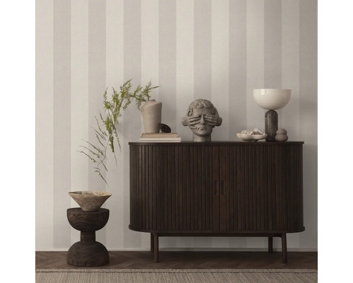 Dekoratives Wohnzimmer mit Kommode, Skulpturen und gestreifter Tapete