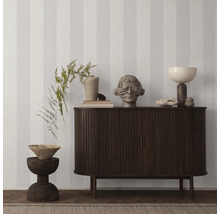 Dekoratives Interieur mit gestreifter Tapete, Kommode, Hocker und Dekorationsgegenständen