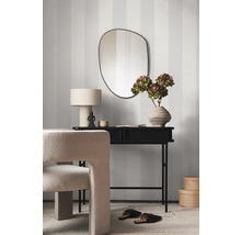 Dekoratives Interieur mit Spiegel, Tisch, Lampe, Stuhl und Blumenvase vor einer gestreiften Wand