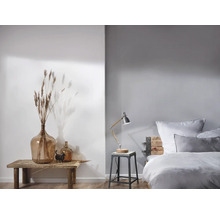 Helles Schlafzimmer mit Holzbett, Tischlampe und Dekoration