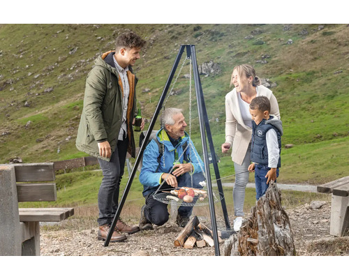 Famille faisant des grillades en plein air avec un barbecue pivotant.
