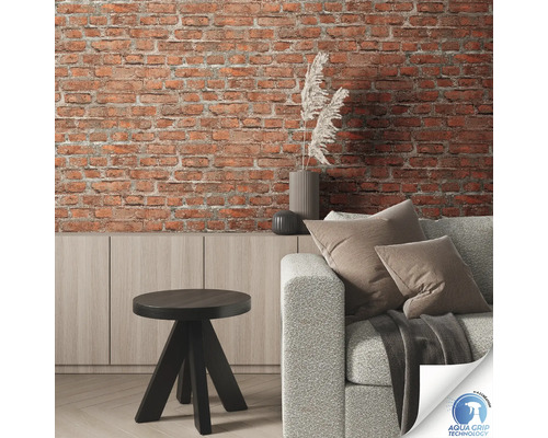 Salon avec mur en briques, canapé, table et commode