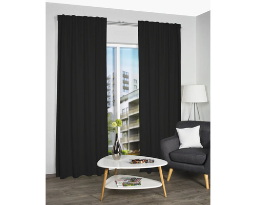 Szene mit schwarzen Vorhängen, Couchtisch und Sessel in einem Wohnzimmer.