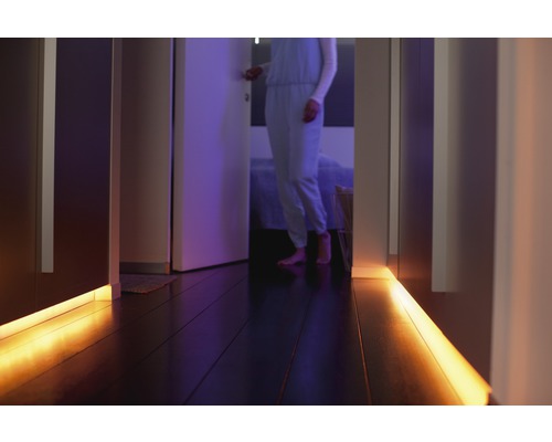 Couloir avec éclairage LED sous les armoires et une personne en arrière-plan