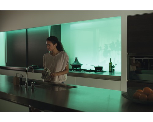 Cuisine moderne avec évier, robinet et une femme tenant un torchon