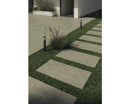 Chemin de jardin avec dalles rectangulaires en pierre dans l''herbe et éclairage de jardin