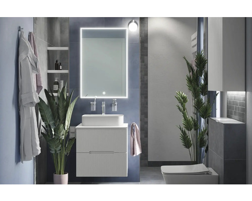 Salle de bains moderne avec lavabo, miroir avec éclairage et toilettes.