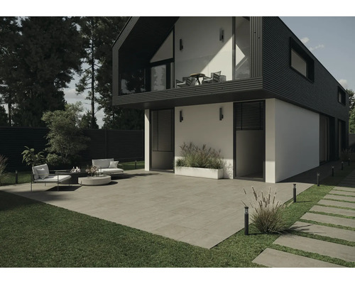 Vue extérieure d''une maison moderne avec terrasse, mobilier de jardin et pavés