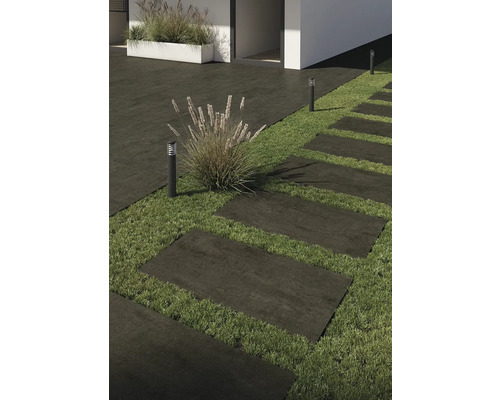 Extérieur avec dalles de terrasse, gazon et éclairage extérieur.